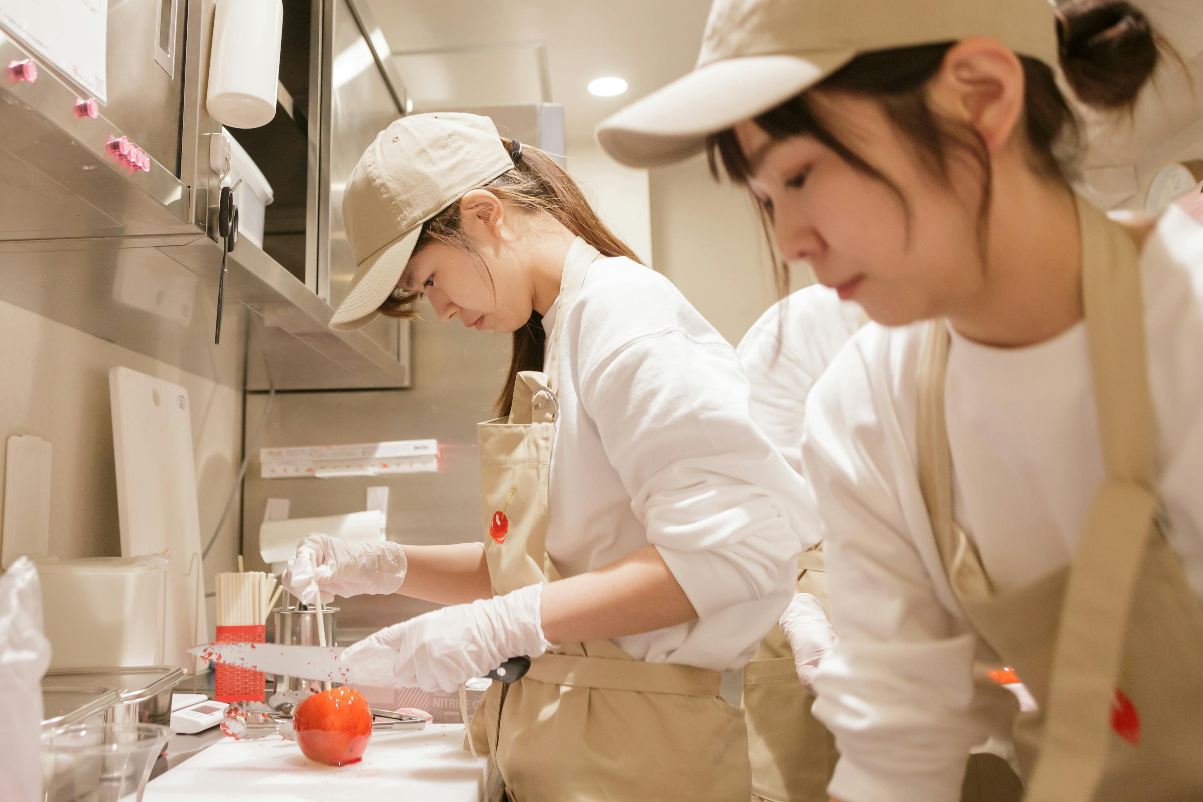 りんごあめを調理・提供する女性の従業員